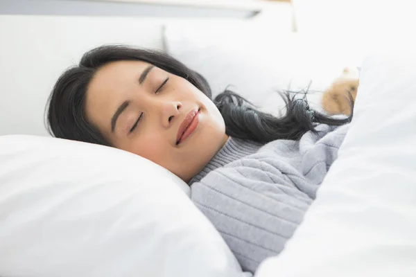 Mulher asiática encontra-se de lado na cama no quarto — Fotografia de Stock