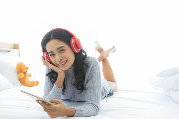 Asiatin trägt Kopfhörer im Schlafzimmer — Stockfoto