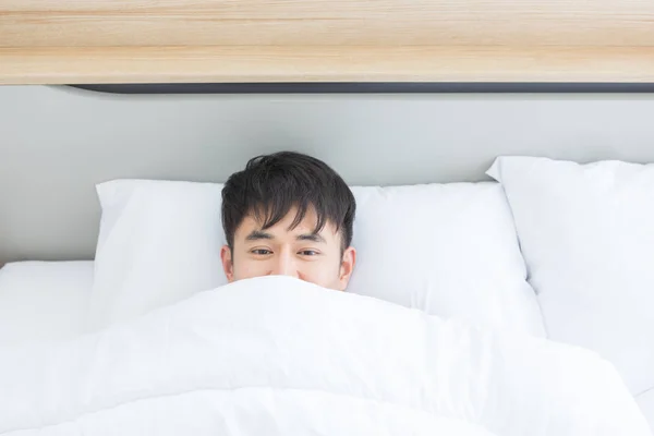 Asian man lying on bed, he slept deep in bedroom