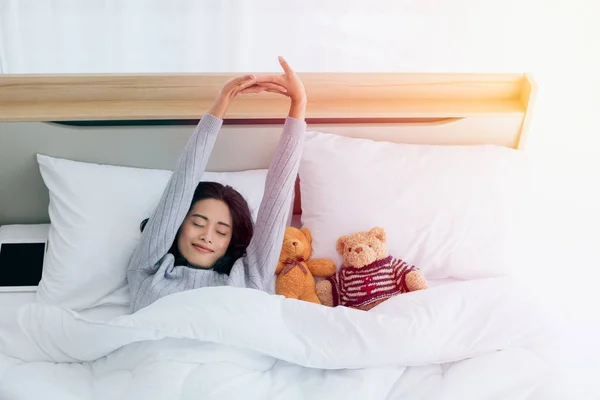 Vrouw liggend in bed en kijkend over de deken — Stockfoto