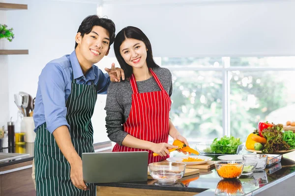 Asiático pareja en delantal stand y sonrisa a cámara —  Fotos de Stock