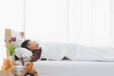 Asyalı adam uyandı çünkü çalar saat onu alarma geçirdi.