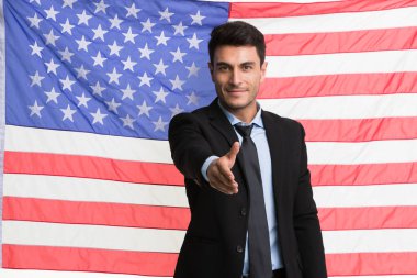 İşadamı Amerikan bayrağı önünde kolları çapraz