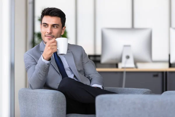 Бізнесмен п'є каву в офісі — стокове фото