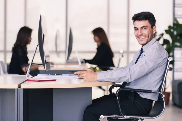 Кавказька бізнесмен сидить і посміхнеться в офісі — стокове фото