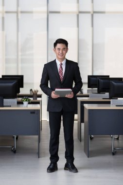 Elinde tablet bilgisayar tutan işadamı.