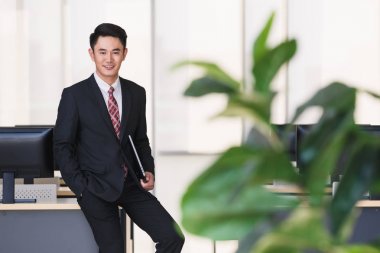 Ofiste defter bilgisayar tutan işadamı