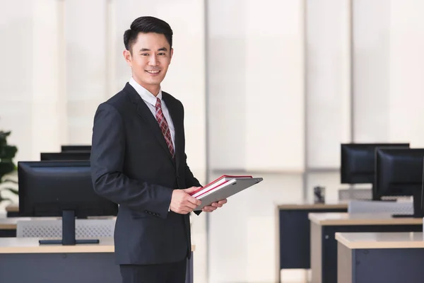 Affärsman hållande anteckningsboken computern i kontor — Stockfoto