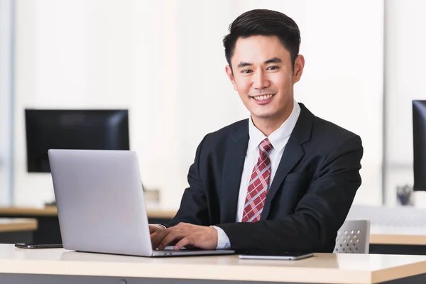 Asiatisk affärsman leende och sittning i Office — Stockfoto