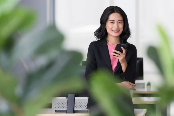 Mujer de negocios hablando con teléfono inteligente en la oficina . —  Fotos de Stock