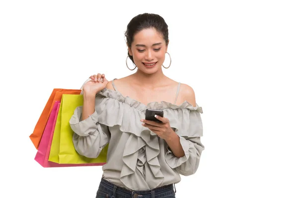 Asijská žena nosí papírové tašky a používá smartphone — Stock fotografie