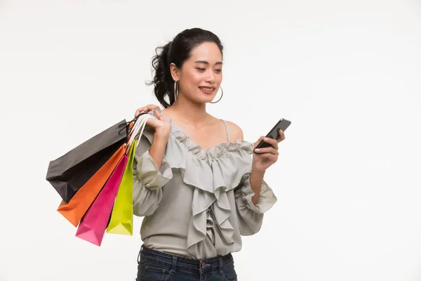 Asian kobieta nosić torby papierowe i używa smartfona — Zdjęcie stockowe