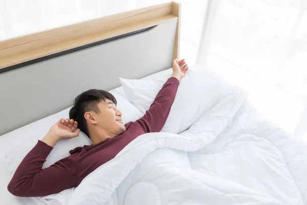 Asiático deitado na cama, ele dormiu profundamente no quarto — Fotografia de Stock