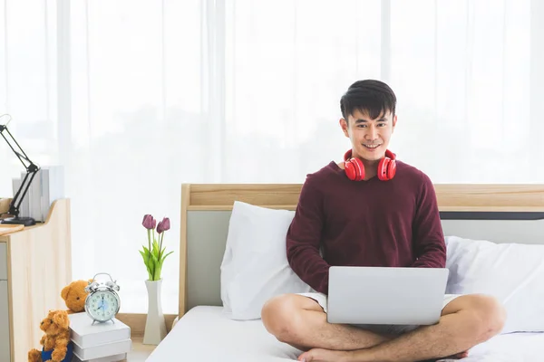 Hombre usando el ordenador portátil y tiene auriculares en el cuello — Foto de Stock