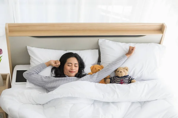 Vrouw liggend in bed en kijkend over de deken — Stockfoto