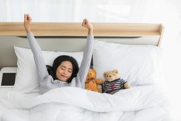 Vrouw liggend in bed en kijkend over de deken — Stockfoto