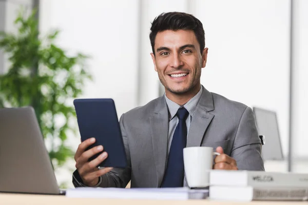 Бизнесмен держит в руках планшетный компьютер — стоковое фото
