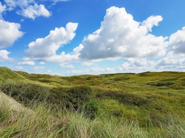 Kumullar ve güzel bulutlu gökyüzü Adası Ameland üzerinde haddeleme
