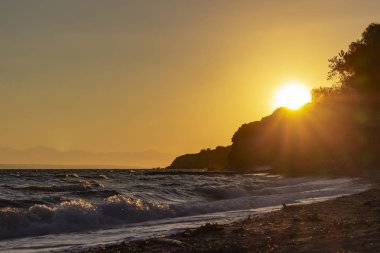Tsilivi, Zakynthos, Yunanistan yakınındaki taş kenarına üzerinde yükselen güneş iletiye göz atar