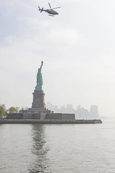 A police helicopter hangs over the Statue of Liberty in New York, United States