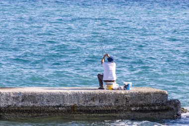 Bir adam bir Dock bağlantı noktası Zakynthos, Yunanistan içinde balık tutma