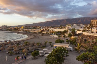 Plaj sandalyeleri sırasında günbatımı üzerinde sahil Costa Adeje, Tenerife, İspanya, ertesi gün için hazır