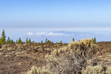 Ada La Gomera (bulutlar yarısı) etrafında El Teide yanardağı engebeli peyzaj üzerinden Gösterim Adası Tenerife, İspanya