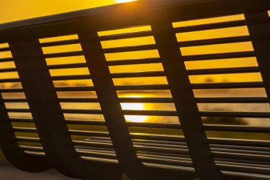 Akşam güneşi göl boyunca bir bankın parmaklıklar ı saran 'Zoetermeerse plas', Hollanda