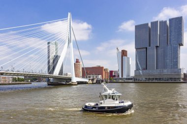 Bir römorkör sadece arka planda Hollanda Americakade üzerinde heybetli binalar ile erasmus köprü geçti