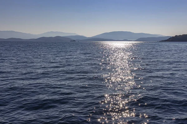 Солнце Создает Тысячи Скользящих Звезд Воде Перед Холмистыми Побережьями Греции — стоковое фото