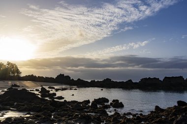 Yükselen güneş Puerto del Carmen Playa Chica Plajı üzerinde bulutlar yaktı, Lanzarote, İspanya