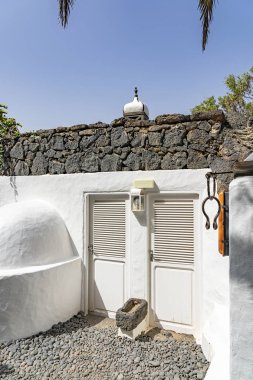 İspanya 'nın Lanzarote adasındaki siyah lav taşından yapılmış duvarları olan beyaz bir evin detayları.