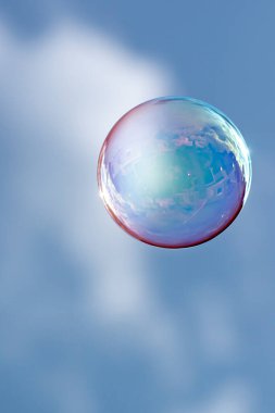 Yüzen bir baloncukta evlerin ve bulutların yansıması