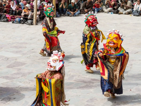 Monks in dharmapala mask with ritual edged weapons perform a religious masked and costumed mystery dance of Tantric Tibetan Buddhism on Cham Dance Festival in Hemis monaster — Stock Photo, Image