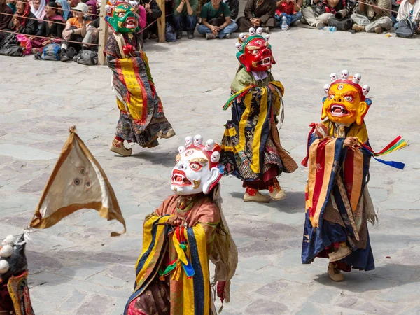 Monks in dharmapala mask with ritual edged weapons perform a religious masked and costumed mystery dance of Tantric Tibetan Buddhism on Cham Dance Festival in Hemis monaster — Stock Photo, Image