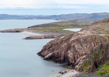 Yaz aylarında sert havalarda Kuzey Kutup Dairesi'nin ötesindeki Barents Denizi'nin kayalık dik sahilinin en iyi manzarapanoraması