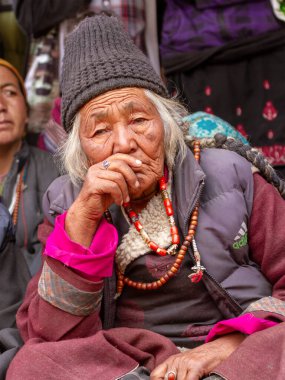 Lamayuru, Hindistan - 17 Haziran 2012: Lamayuru Manastırı 'ndaki Budist Yuru Kabgyat festivalini izleyen gözlemciler arasında geleneksel giysiler ve takılar içindeki yaşlı gri saçlı ladakhi kadınlar