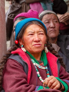 Lamayuru, Hindistan - 17 Haziran 2012: Lamayuru Manastırı 'ndaki Budist Yuru Kabgyat festivalini izleyen gözlemciler arasında geleneksel giysiler ve mücevherlerle dua eden yaşlı ladakhi kadınları