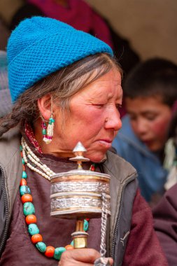 Lamayuru, Hindistan - 17 Haziran 2012: Geleneksel giysiler içinde el dua tekerlekleri ve takı duaları yapan yaşlı gri saçlı ladakhi kadınları, Budist Yuru Kabgyat manastırında düzenlenen festivalde gözlemci kalabalığının arasında gözleri kapalı dua ediyorlar.
