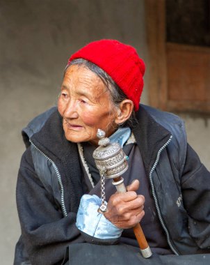 Lamayuru, Hindistan - 17 Haziran 2012: Budist Yuru Kabgyat festivalinin Lamayuru manastırındaki izleyiciler arasında geleneksel giysileri içinde el dua tekerleği takan, dost canlısı gri saçlı ladakhi kadınları