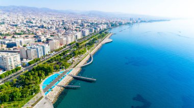 Kıbrıs Limasol sahil kent merkezinde hava görünümünü Molos Promenade Park. Kuş bakışı jetties, sahil yürüyüş yolu, palmiye ağaçları, Akdeniz, iskeleler, kayalar, şehir manzarası ve port yukarıdan.