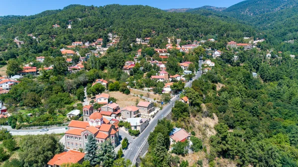 Pano Platres köyü, kışlık tatil beldesi, Troodos dağları, Limasol, Kıbrıs. Çam ağaçlarının kuş bakışı manzarası, kırmızı çatılı evler, oteller, yukarıdan panagias faneromenis kilisesi.