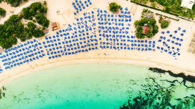 Ünlü Makronissos sahil şeridi Ayia Napa, Famagusta, Kıbrıs 'ın havadan kuş bakışı manzarası. Günbatımında Agia Napa 'da altın kum, güneşlik, deniz restoranları ve yaz tatilleri ile turistik mekan Makronisos Körfezi..