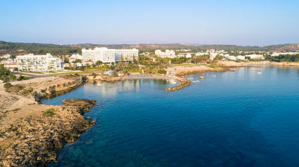 Aerial bird\'s eye view of Green bay in Protaras, Paralimni, Famagusta, Cyprus. The famous tourist attraction diving location rocky beach with boats, sunbeds, restaurants, water sports, people swimming in sea on summer holidays, from above.