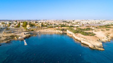 Kıbrıs Rum Kesimi 'nin Protaras, Paralimni, Famagusta kentindeki Kapparis (itfaiyeci) plajının havadan kuş bakışı görüntüsü. Ünlü turistik eğlence tekneleri, güneşli yatakları, restoranları, su sporları olan, yaz tatillerinde denizde yüzen insanlar