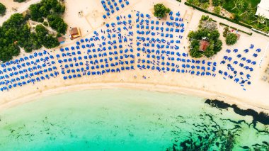 Ünlü Makronissos sahil şeridi Ayia Napa, Famagusta, Kıbrıs 'ın havadan kuş bakışı manzarası. Günbatımında Agia Napa 'da altın kum, güneşlik, deniz restoranları ve yaz tatilleri ile turistik mekan Makronisos Körfezi..