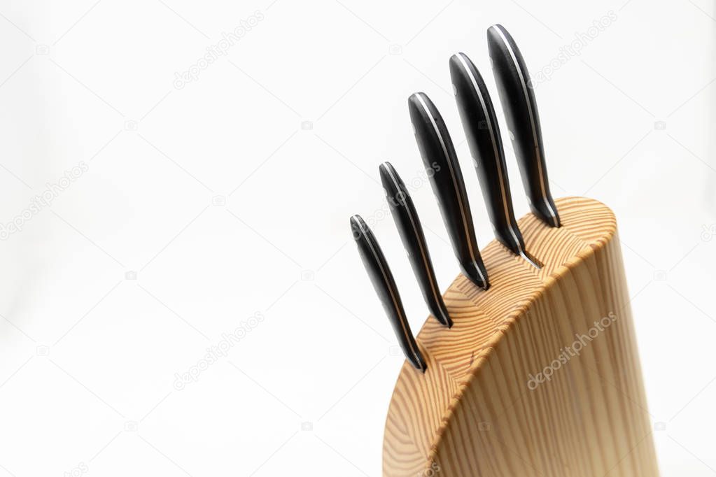 The handles and top of a knife block against a white background