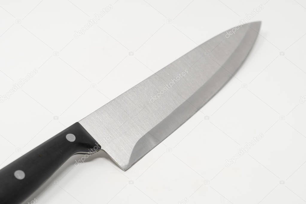 An angled stainless steel kitchen knife set against a white background