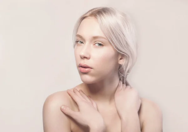 白いスタジオに座っているきれいな肌と美しいブロンドの女の子 — ストック写真