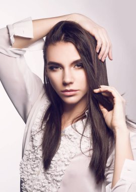 Çift cinsiyetli modeli ile uzun parlak saç oynayan beyaz arka plan üzerinde poz gömlekli portresi